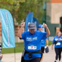 Participants nearing finish line celebrating by holding hands in the air